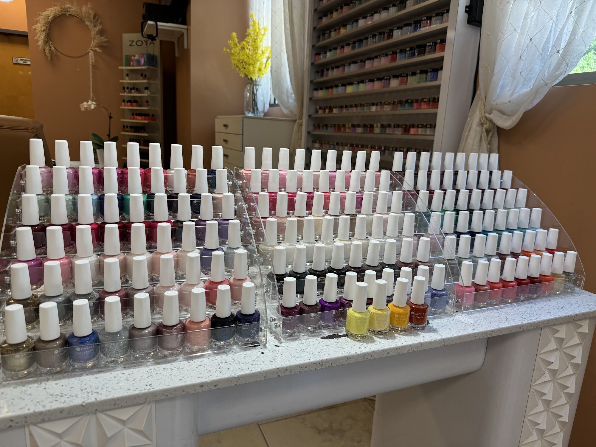 Large collection of gel polish bottles on an acrylic stand