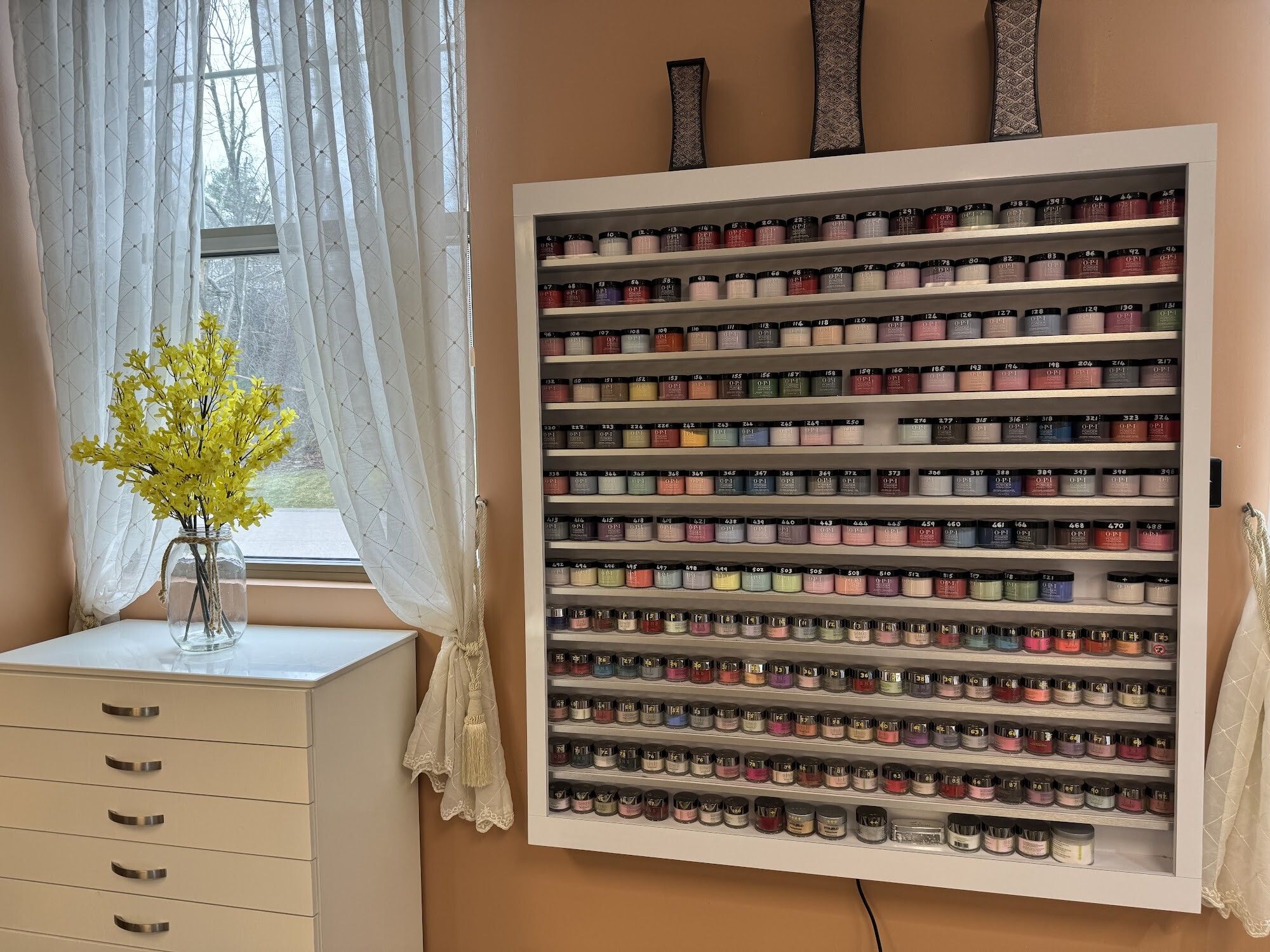 Nail polish display wall beside a sunny window